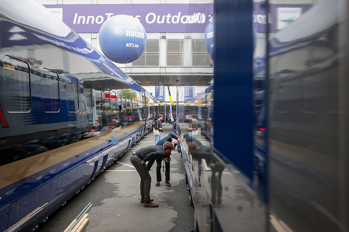 Fotografía de un visitante de Innotrans 2026 viendo un tren de la exposión