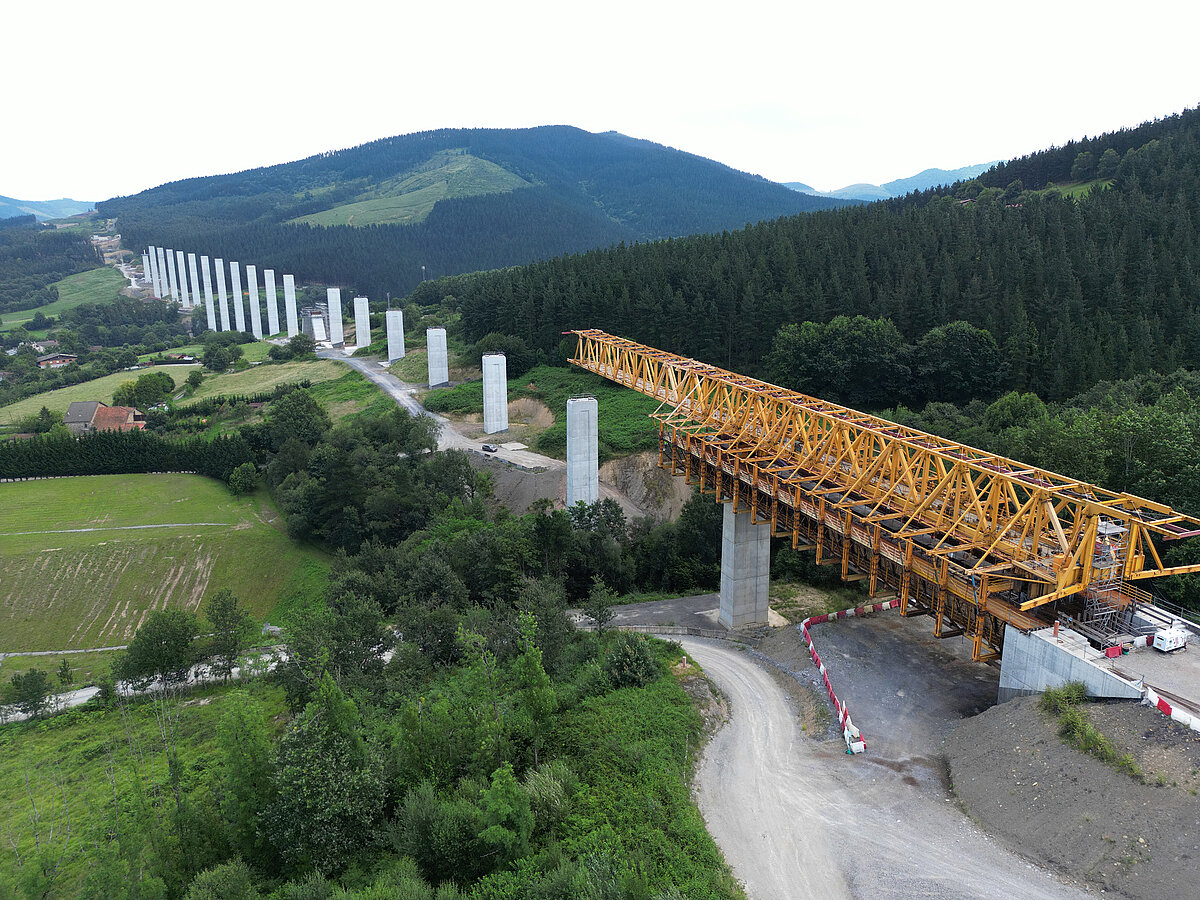 Obras de la Y Vasca - Estructura metálica amarilla de lanzamiento colocada sobre pilares de hormigón en la construcción de un viaducto ferroviario,...